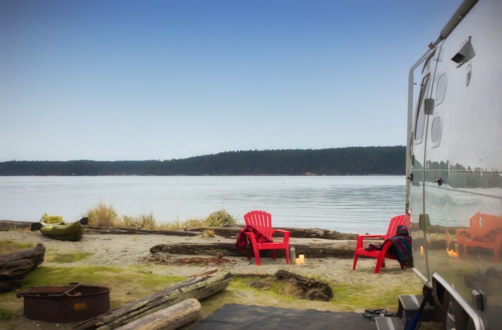 Airstream camp by the water mountain range