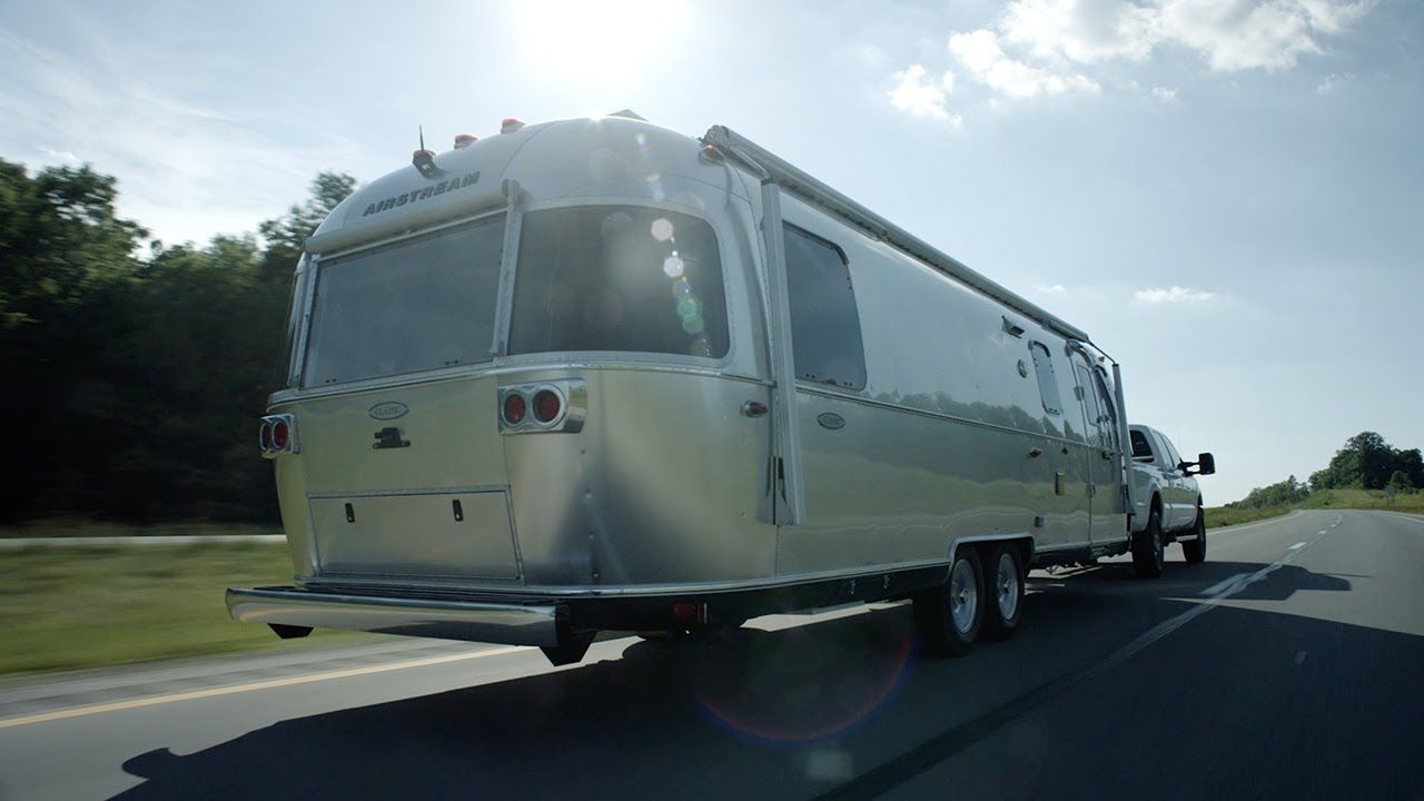 Airstream Travel Trailer aluminum Classic towing road trees sun sky