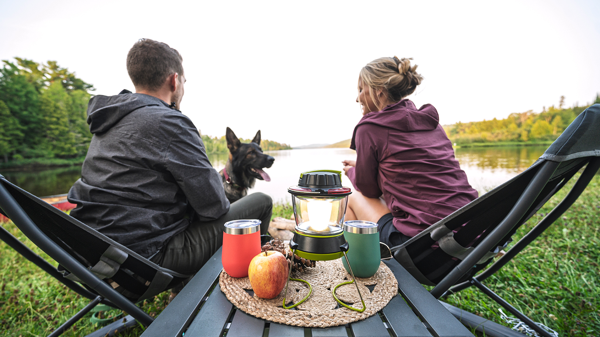 Two people sitting outside with their dog