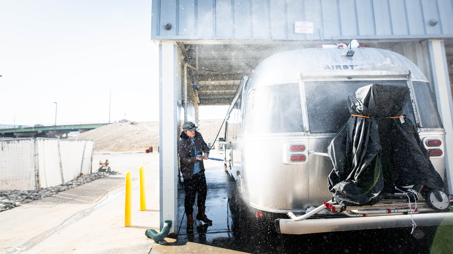 A man cleaning the outside of his Airstream travel trailer.