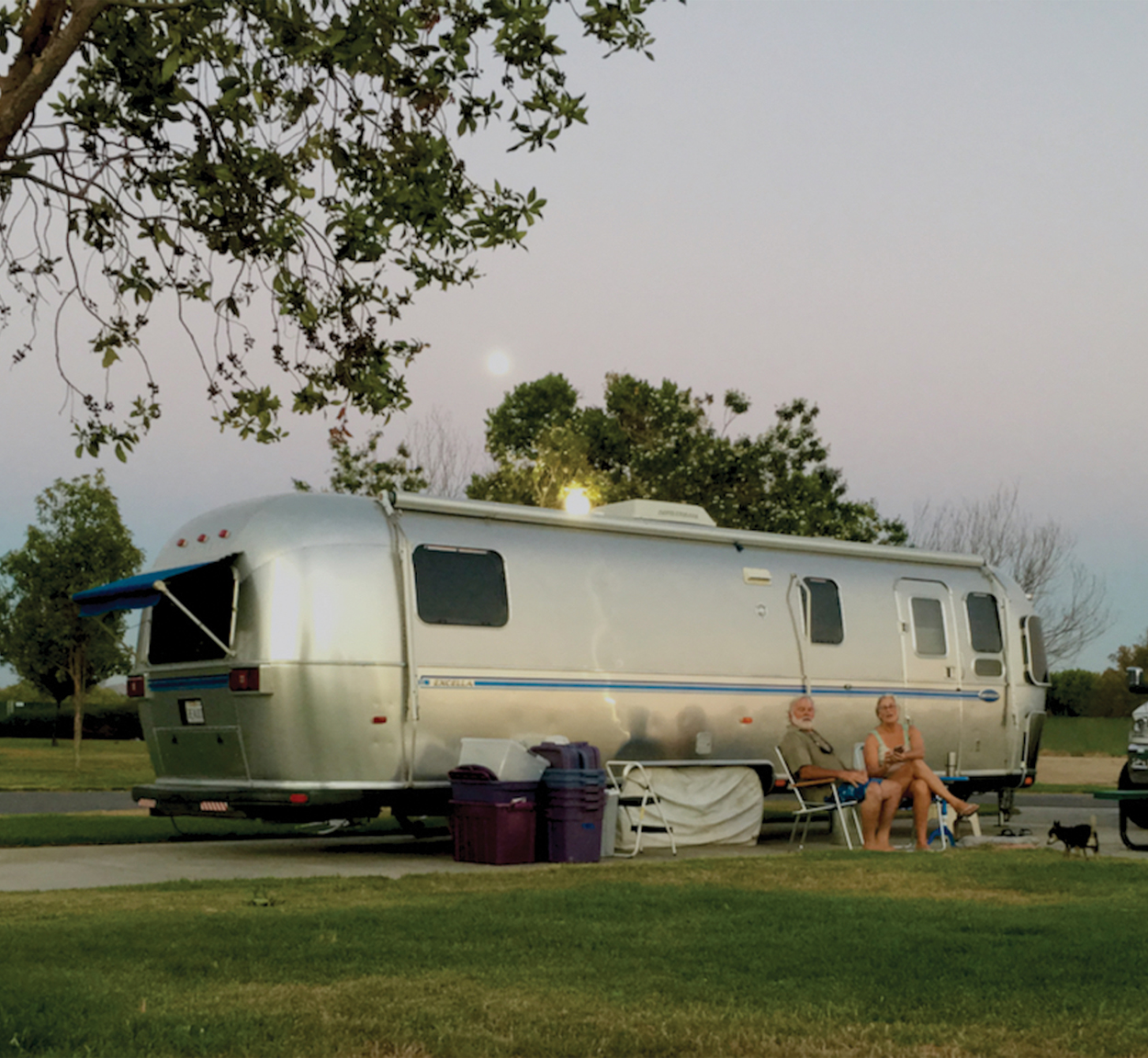 Jim and Carmen sitting outside of their Airstream Travel Trailer