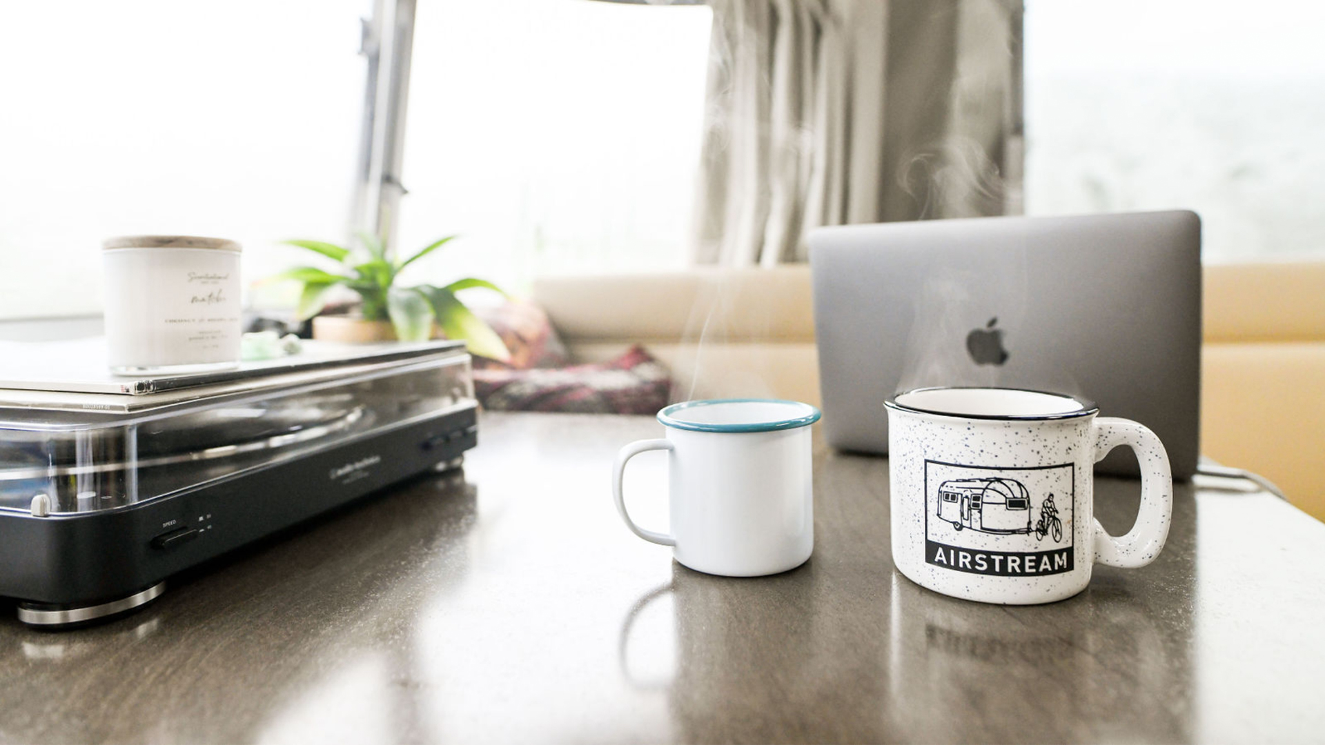 Cup of coffee sitting by laptop in Airstream Travel Trailer