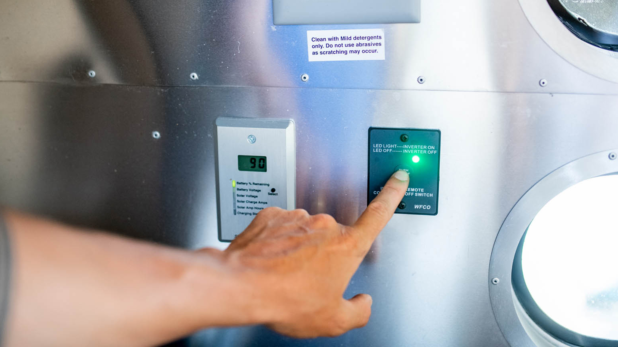 A person turning on their power system in their Airstream travel trailer.