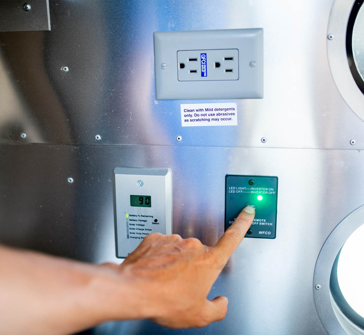 A person turning on their power system in their Airstream travel trailer.