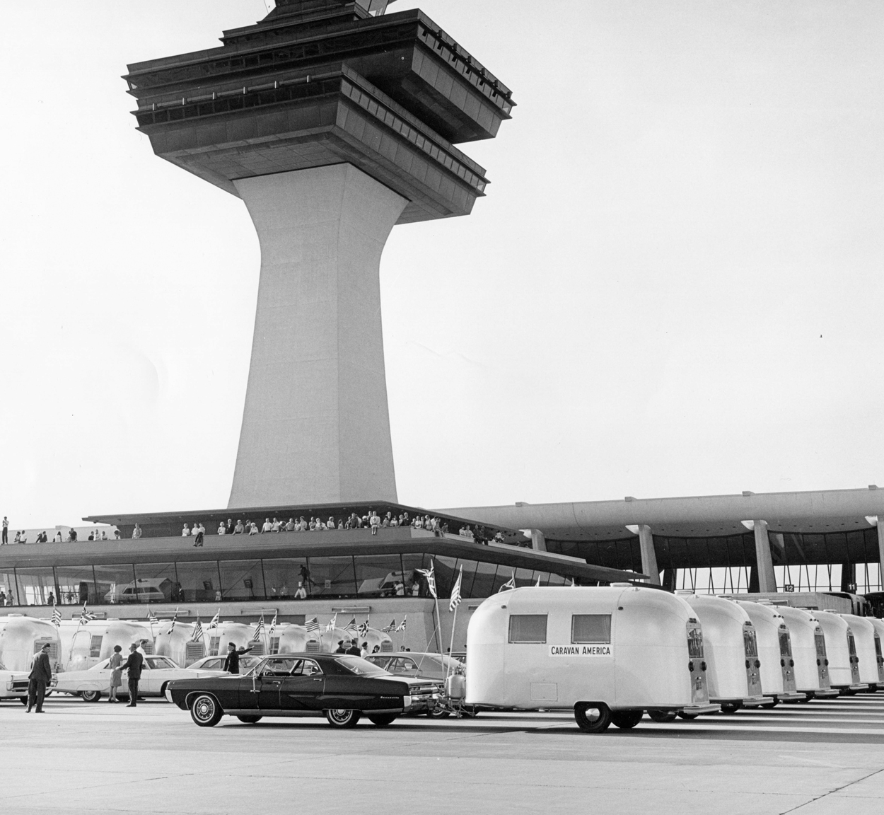 Airstream travel trailers lined up in front of a tall building during Airstream's Caravan America