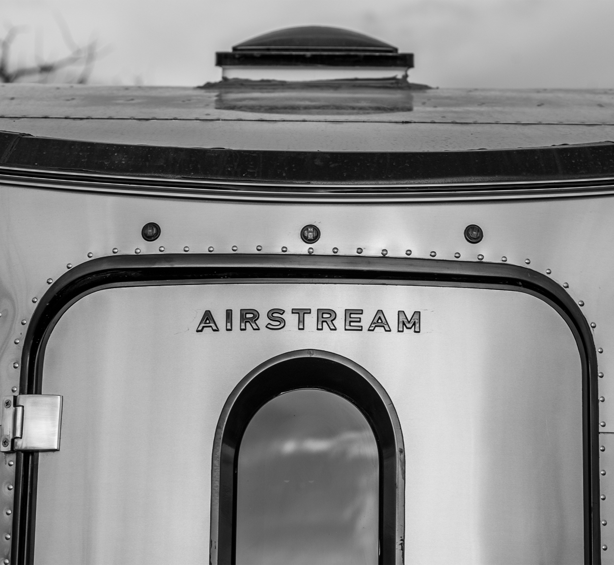 The rear of an Airstream Basecamp travel trailer that is in the snow.