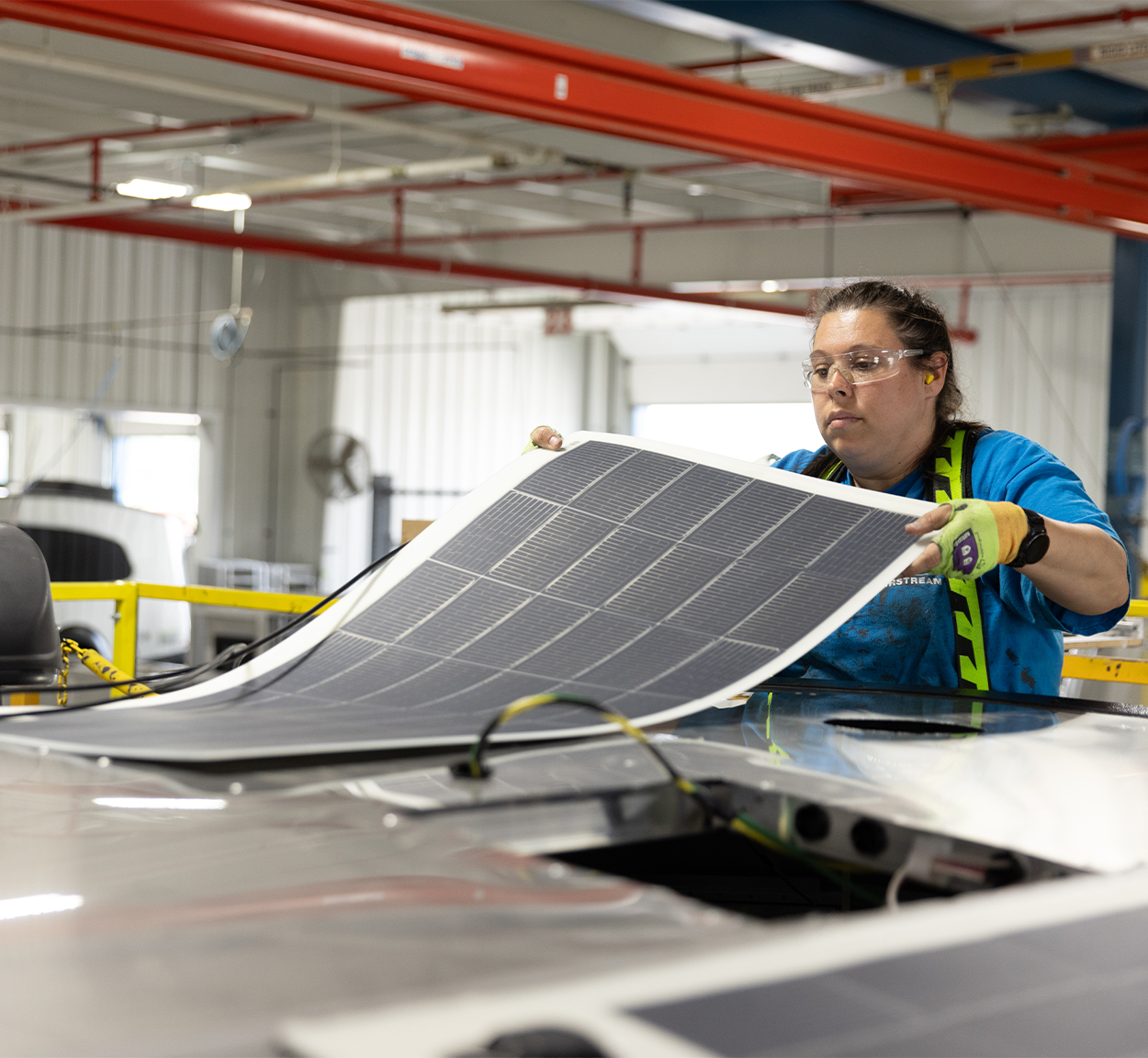 An Airstream employee putting on the solar panels on an Airstream Basecamp travel trailer in Ohio.