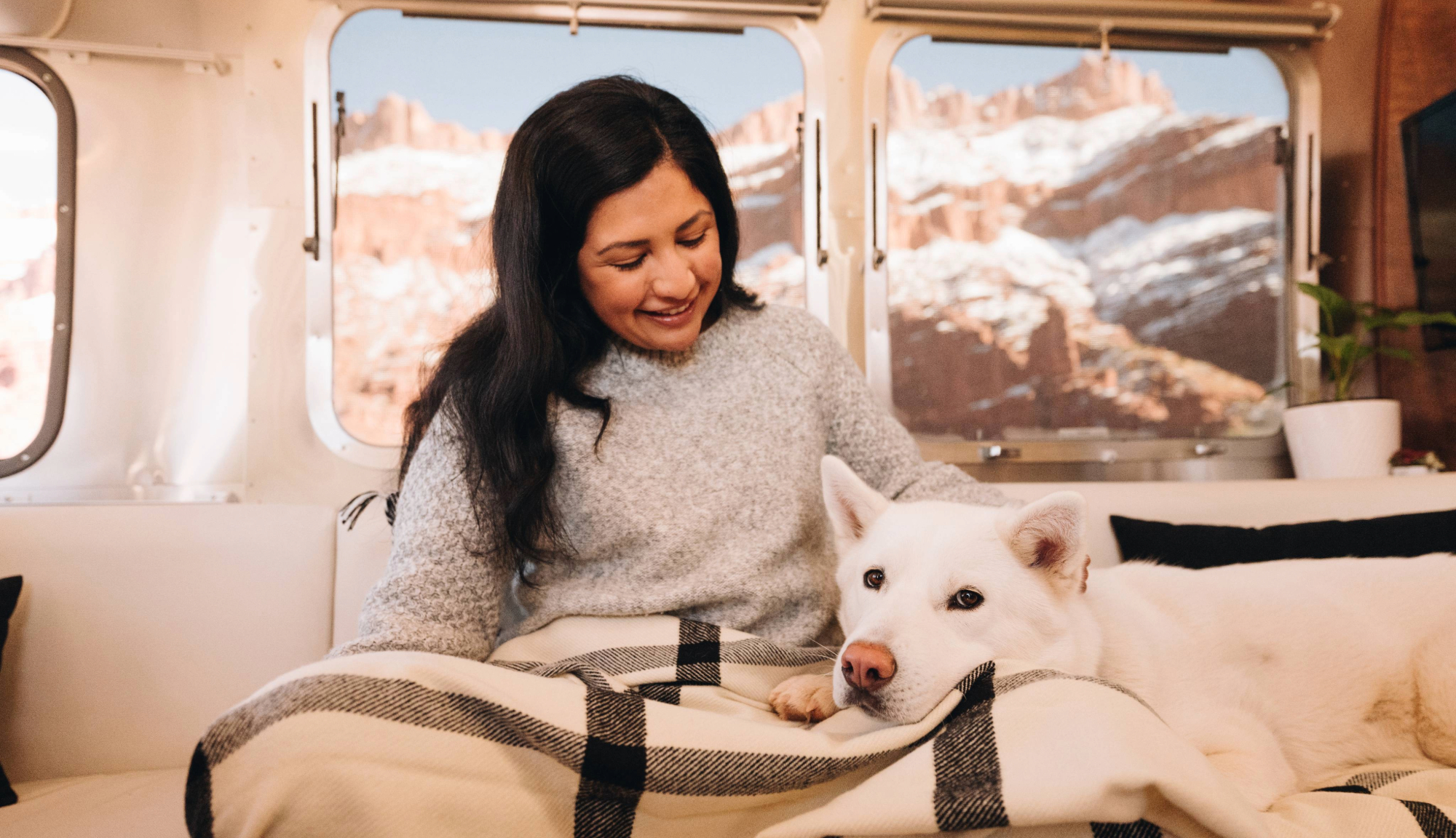 Airsreamer and dog sitting comforably in their Travel Trailer 