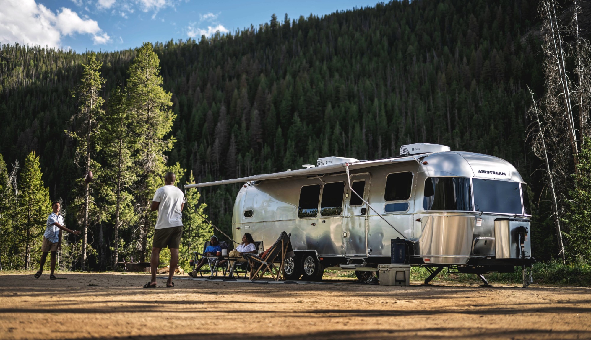 Lifestyle image of a family playing outside of the Flying Cloud Travel Trailer