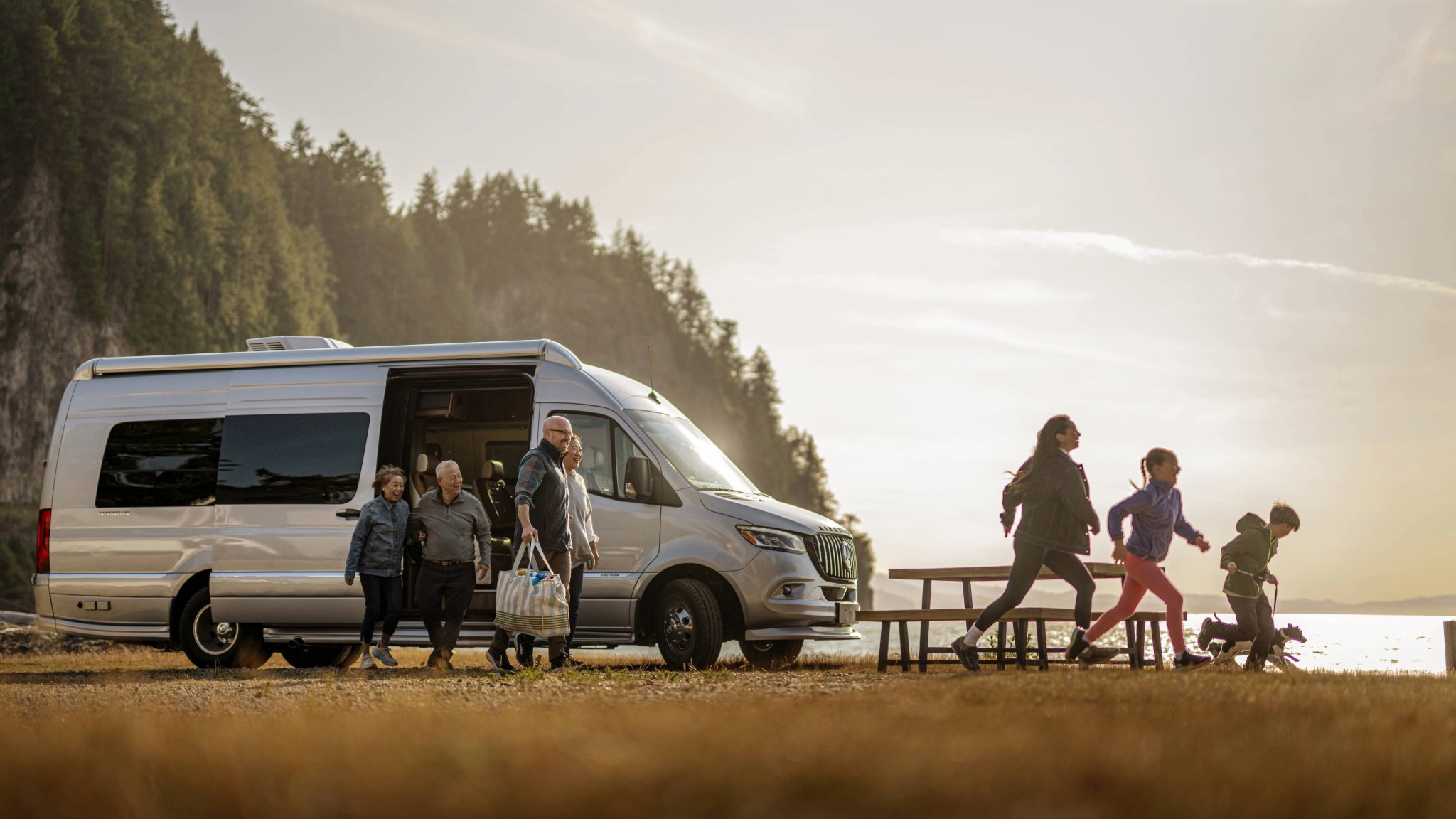 Lifestyle imagery of a family exiting the Interstate 24GL Amber Ridge Decor Touring Coach