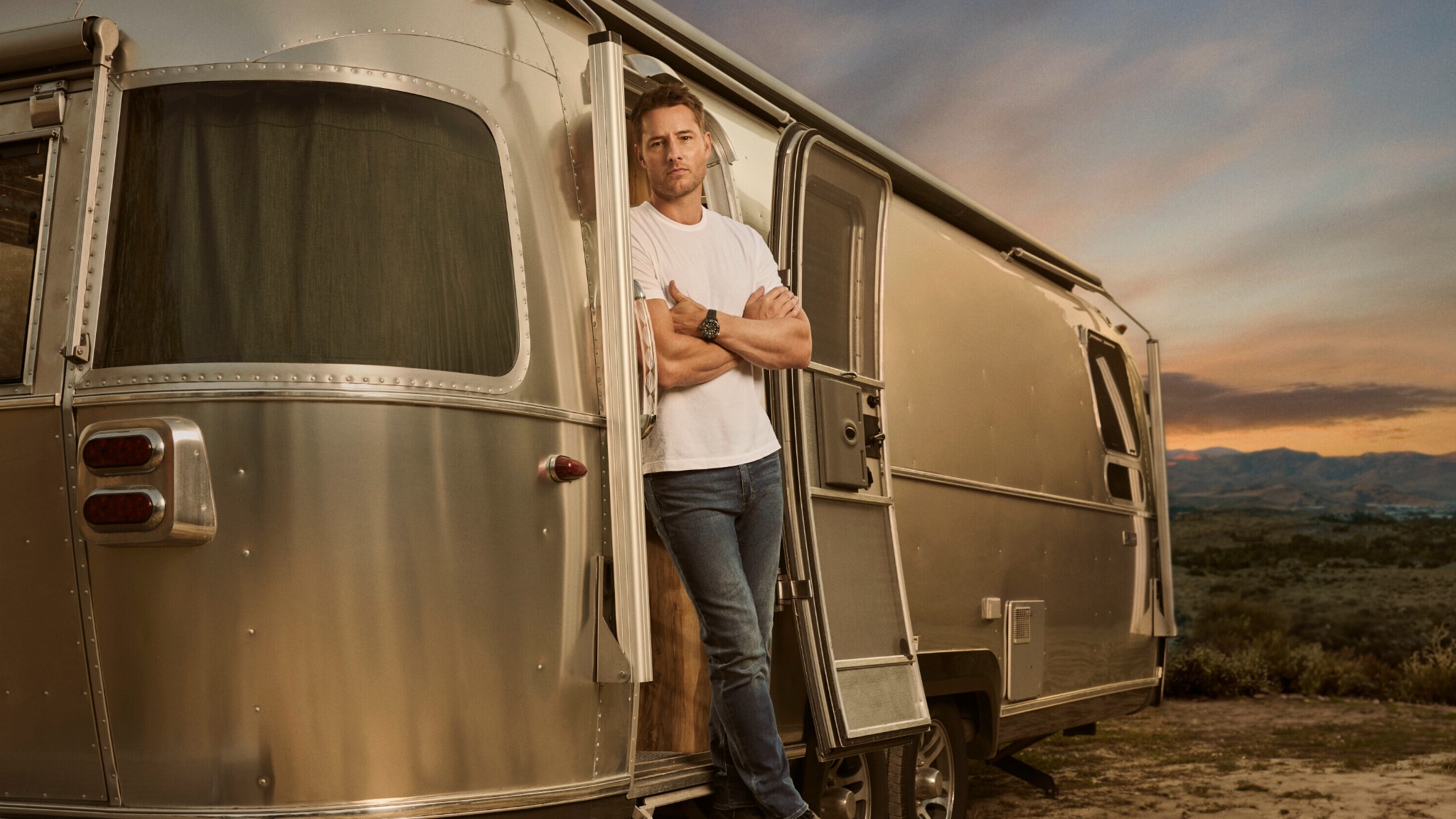 Justin Hartley standing outside Airstream Travel Trailer featured in the show 'Tracker'