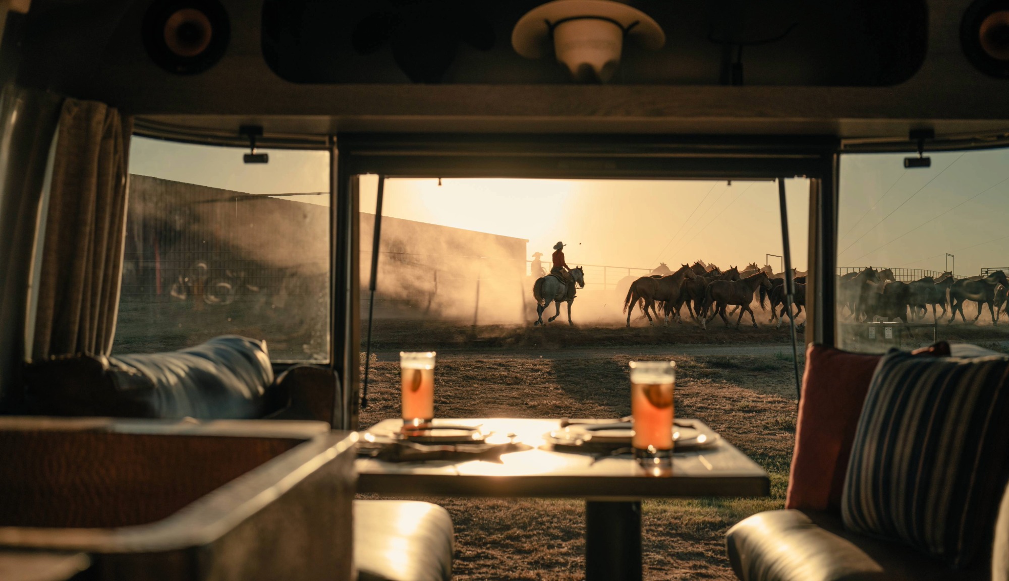 Stetson + 6666s Limited Edition Travel Trailer Interior image with the hatch open, overlooking cowboys riding on the Yellowstone ranch 