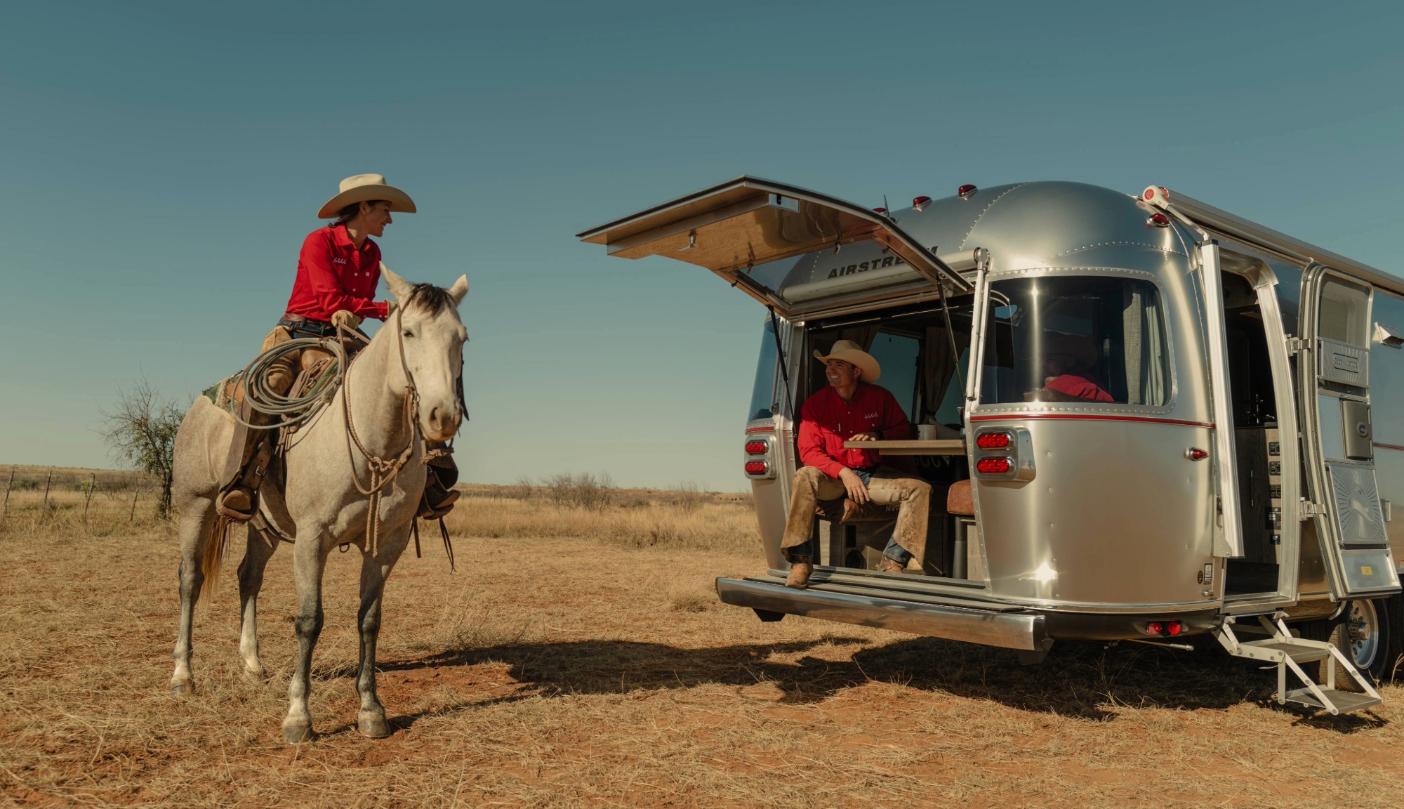 Yellowstone cowboys sitting outside the Stetson + 6666s Limited Edition Trailer with the hatch open