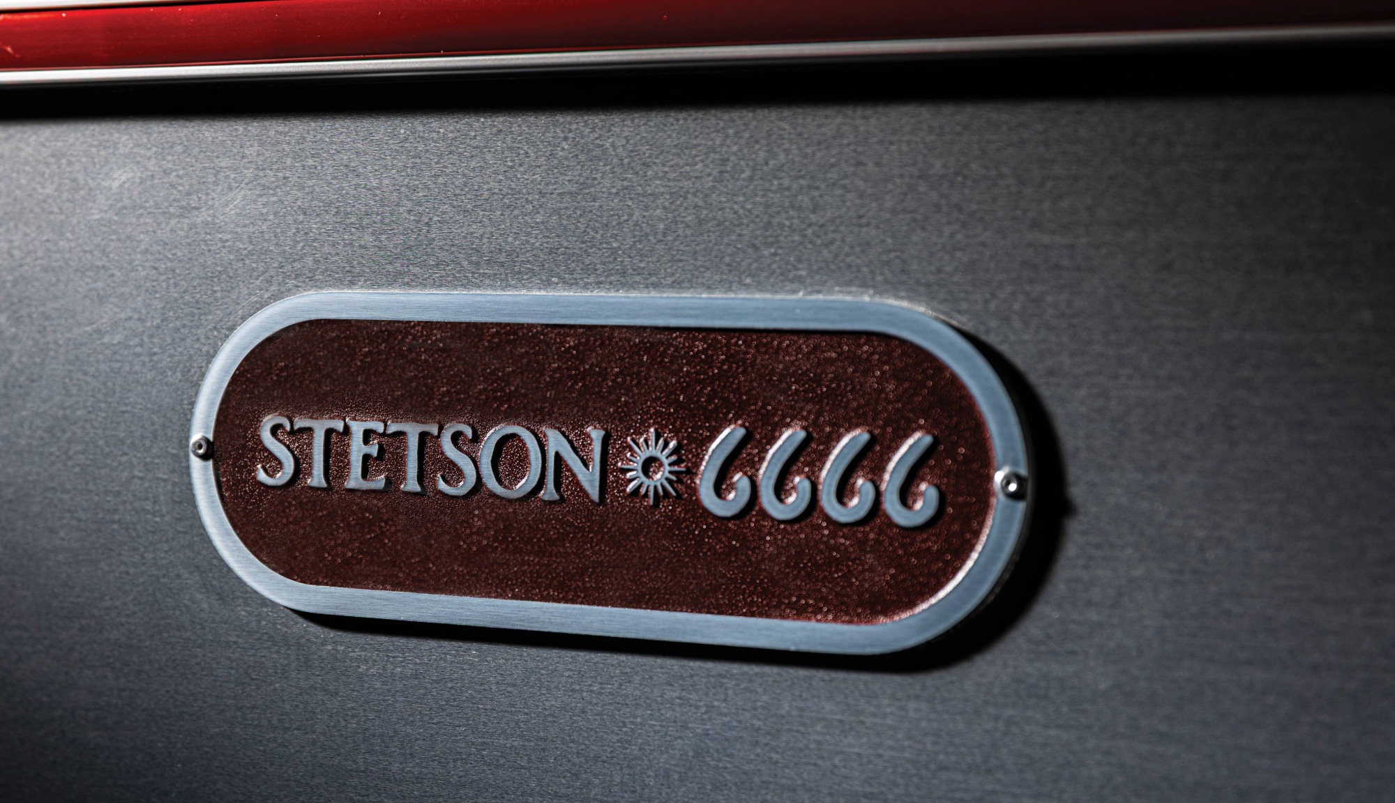 Exterior Closeup of the Stetson + 6666s Badge and Red Rub Rail featured on the Travel Trailer