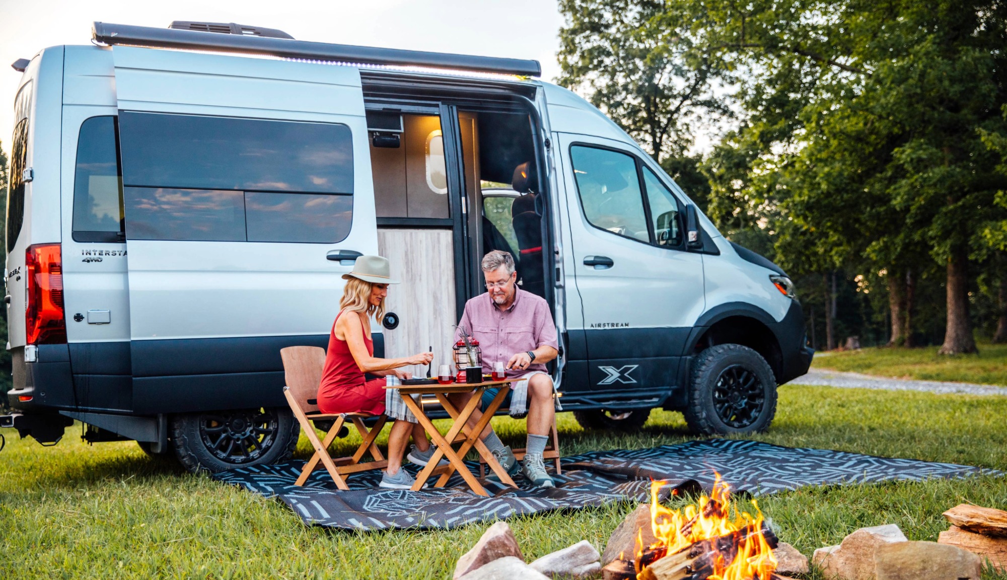 Couple camping outside an Airrstream Interstate 19X Touring Coach