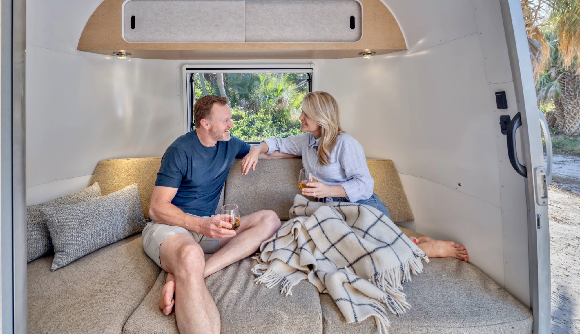 Marc and Tricia Leach lounging on World Traveler Dinette in bed position 