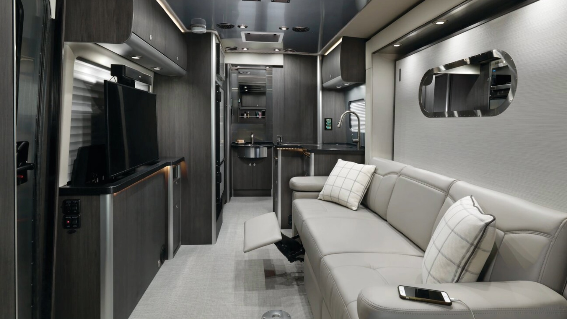 Atlas 25MS Class B Camper Van Sofa with legs extended and flatscreen tv out