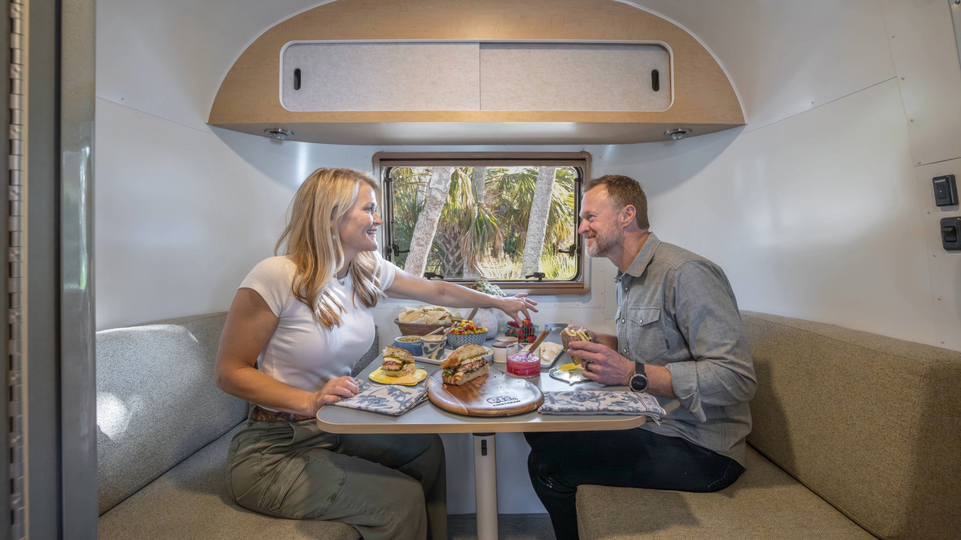 Marc and Trish, Keep Your Daydream eating at their dinette in the Airstream World Traveler
