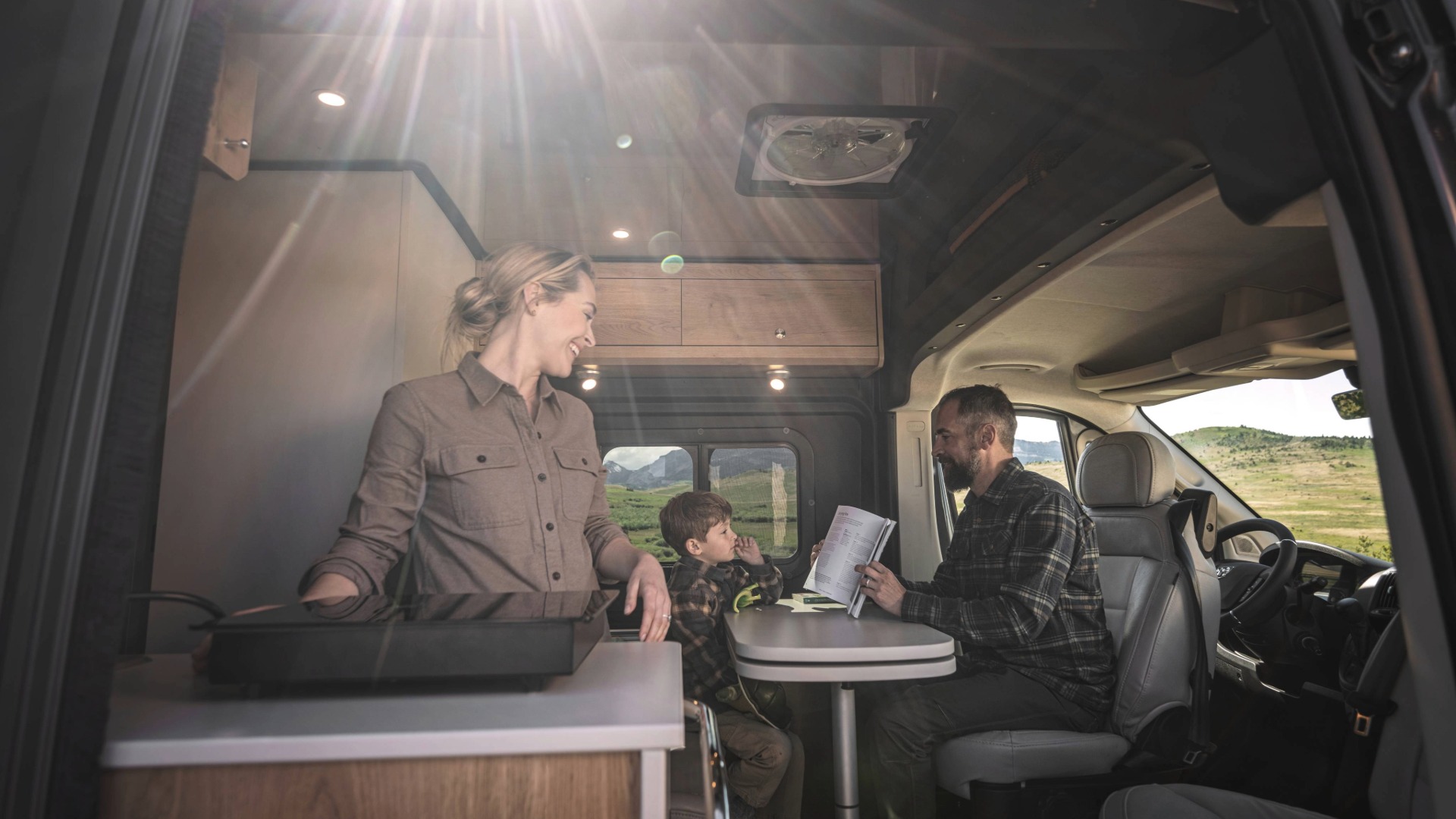 Family lounging inside the Airstream Rangeline Touring Coach galley space